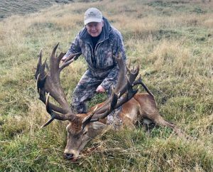 Hunter posing with his red stag trophy